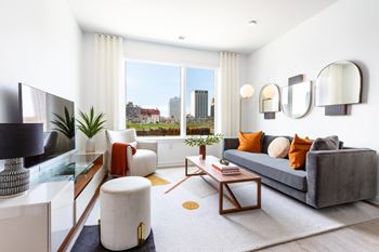 A living room with a gray couch and a large window